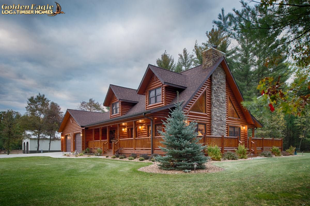 front corner of log cabin showing shrubbery on side and front covered porch