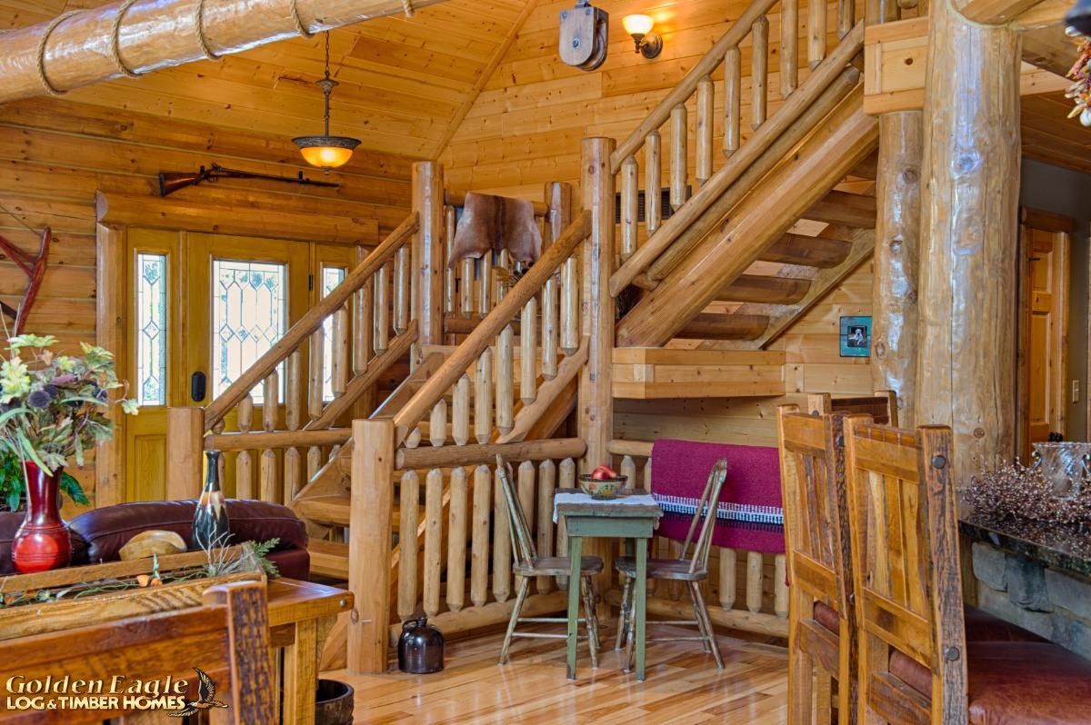 log stairs to second floor of log cabin with breakfast nook by stairs