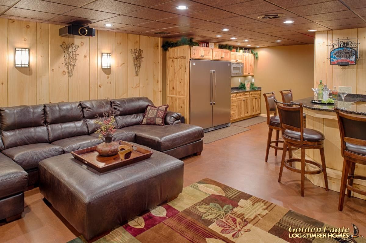 brown leather sofa with large ottoman in basement of log cabin