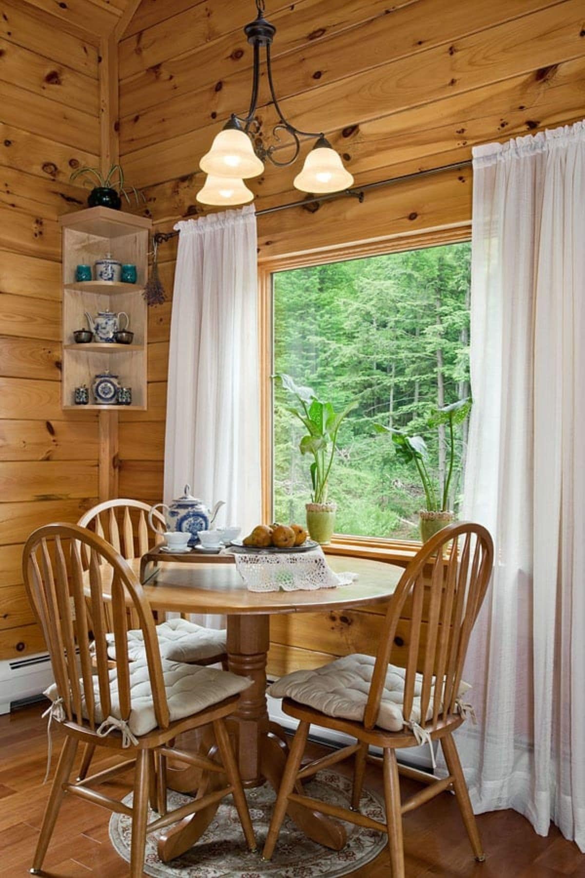wood four person table against window with white curtains