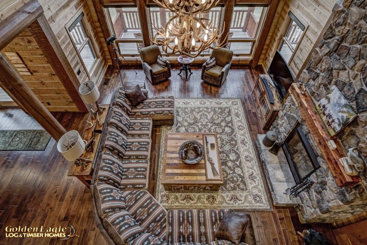 view down into great room from loft with big picture windows on far side