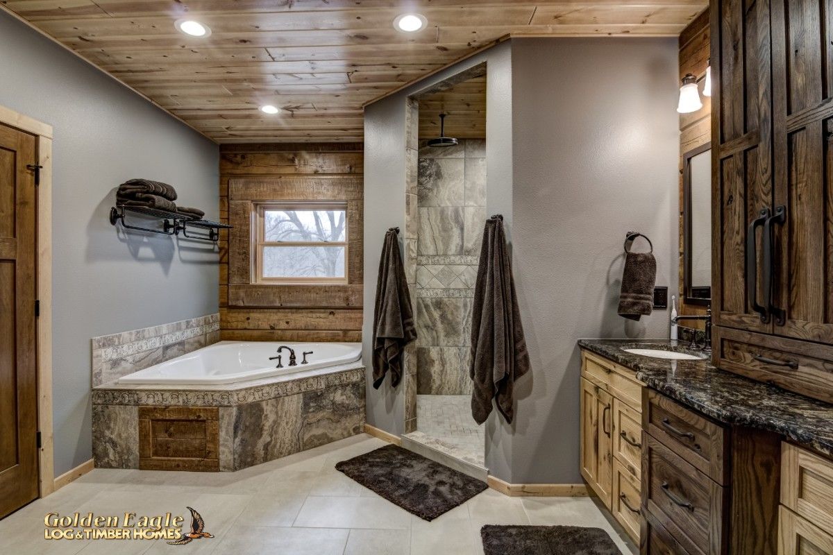 corner soaking tub on left with open shower on right of bathroom with gray walls