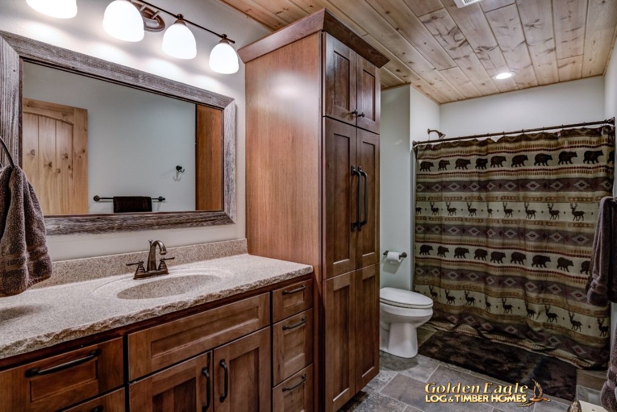 dark wood cabinets in bathroom with rustic shower curtain at back of image