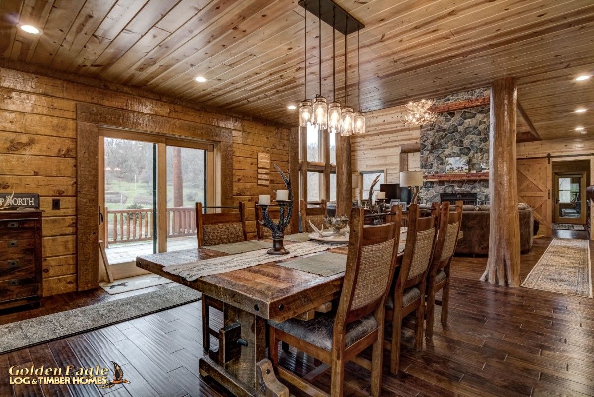 wood dining table underneath long black fixture with dangling lights