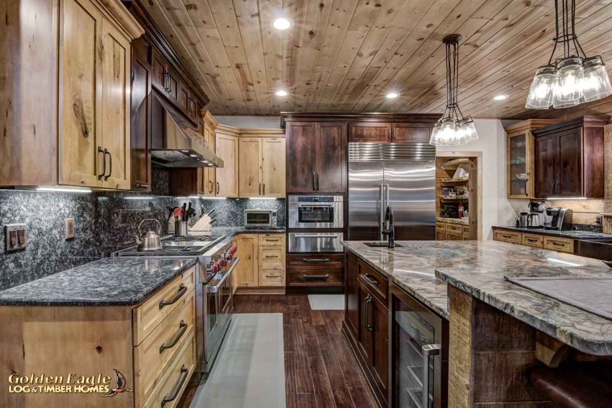 view looking down kitchen between island and cabinets with stainless steel appliances