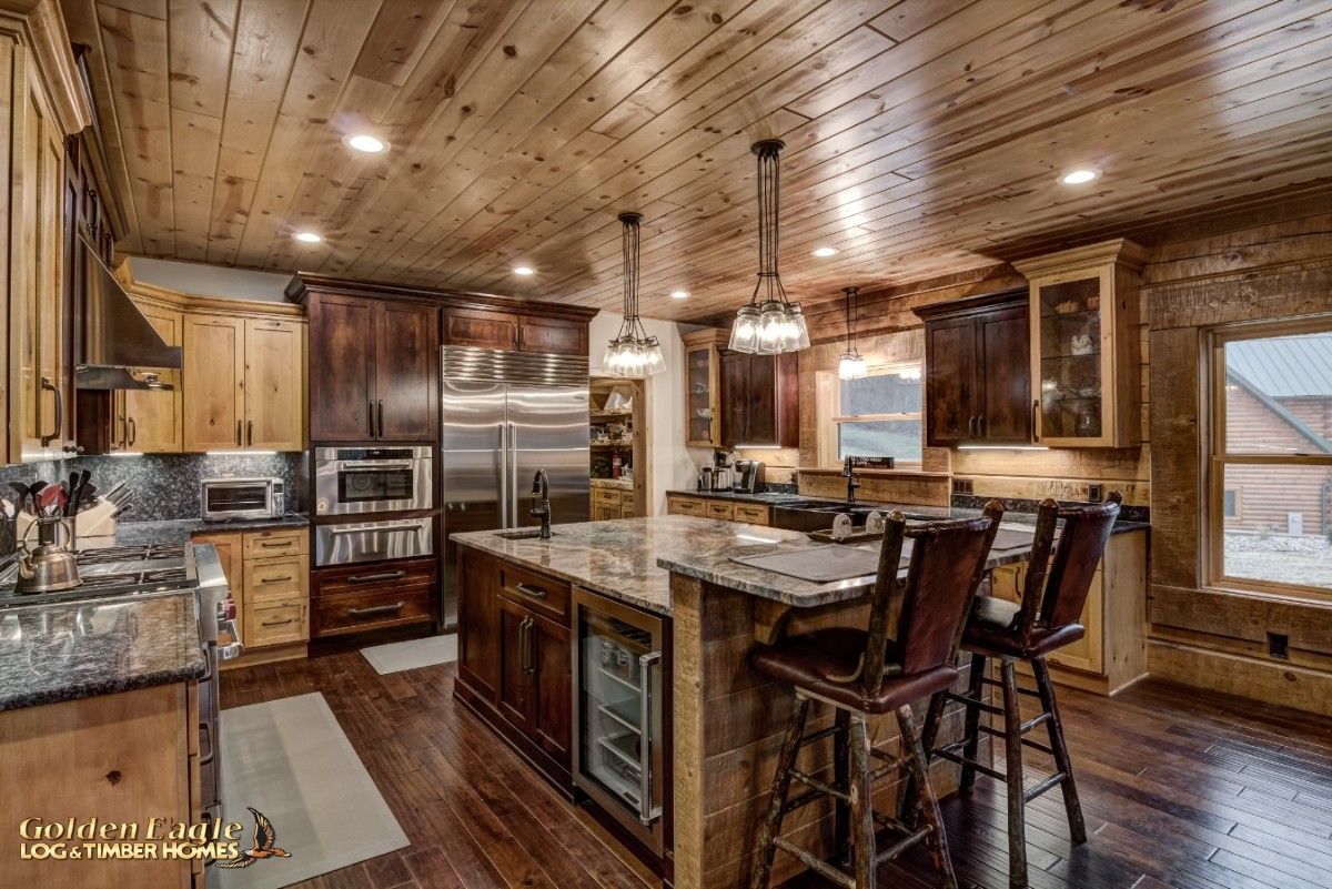 dark wood cabinets with dark wood stools in foreground of kitchen