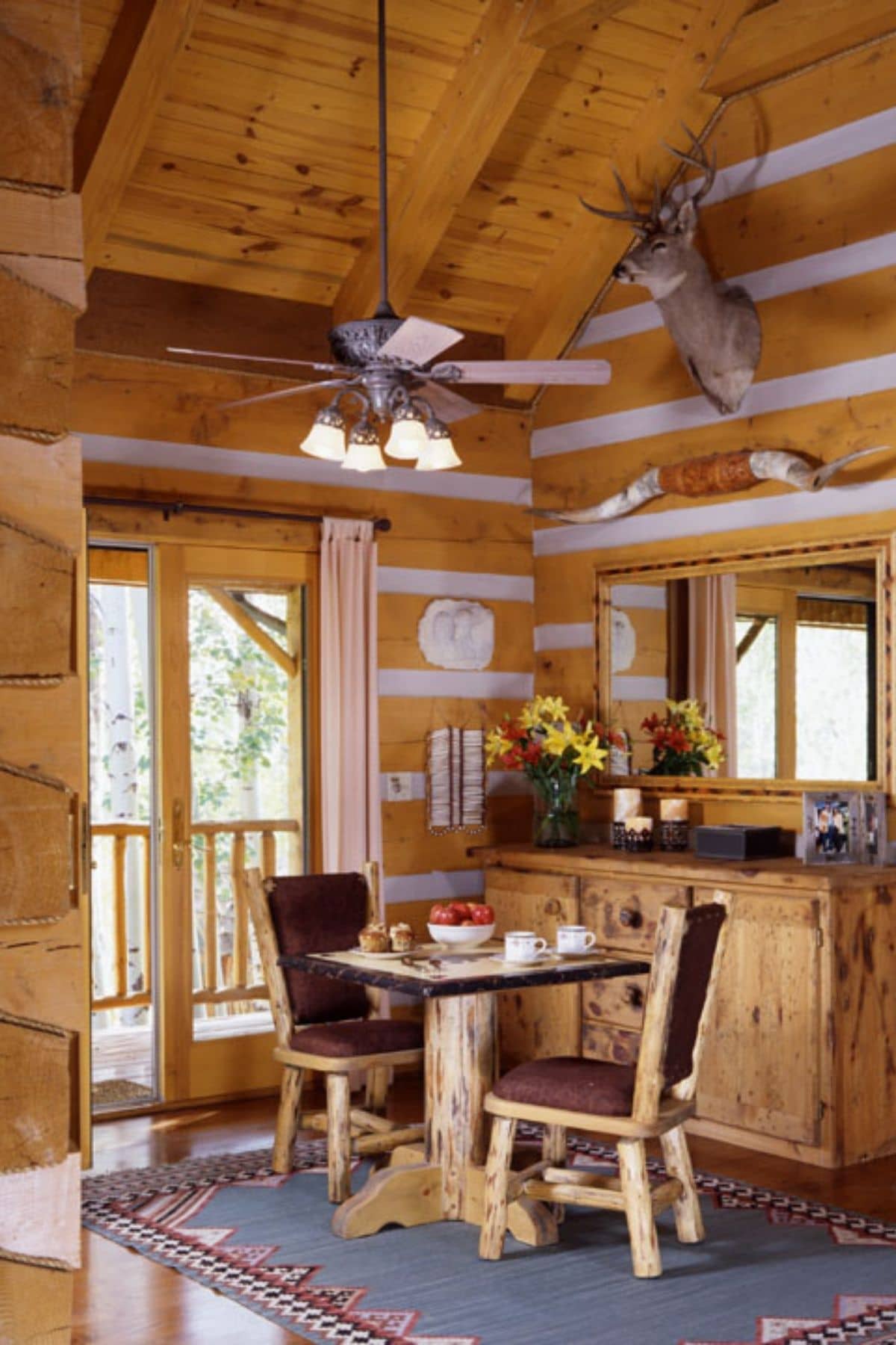 log cabin kitchen with two person table against patio door