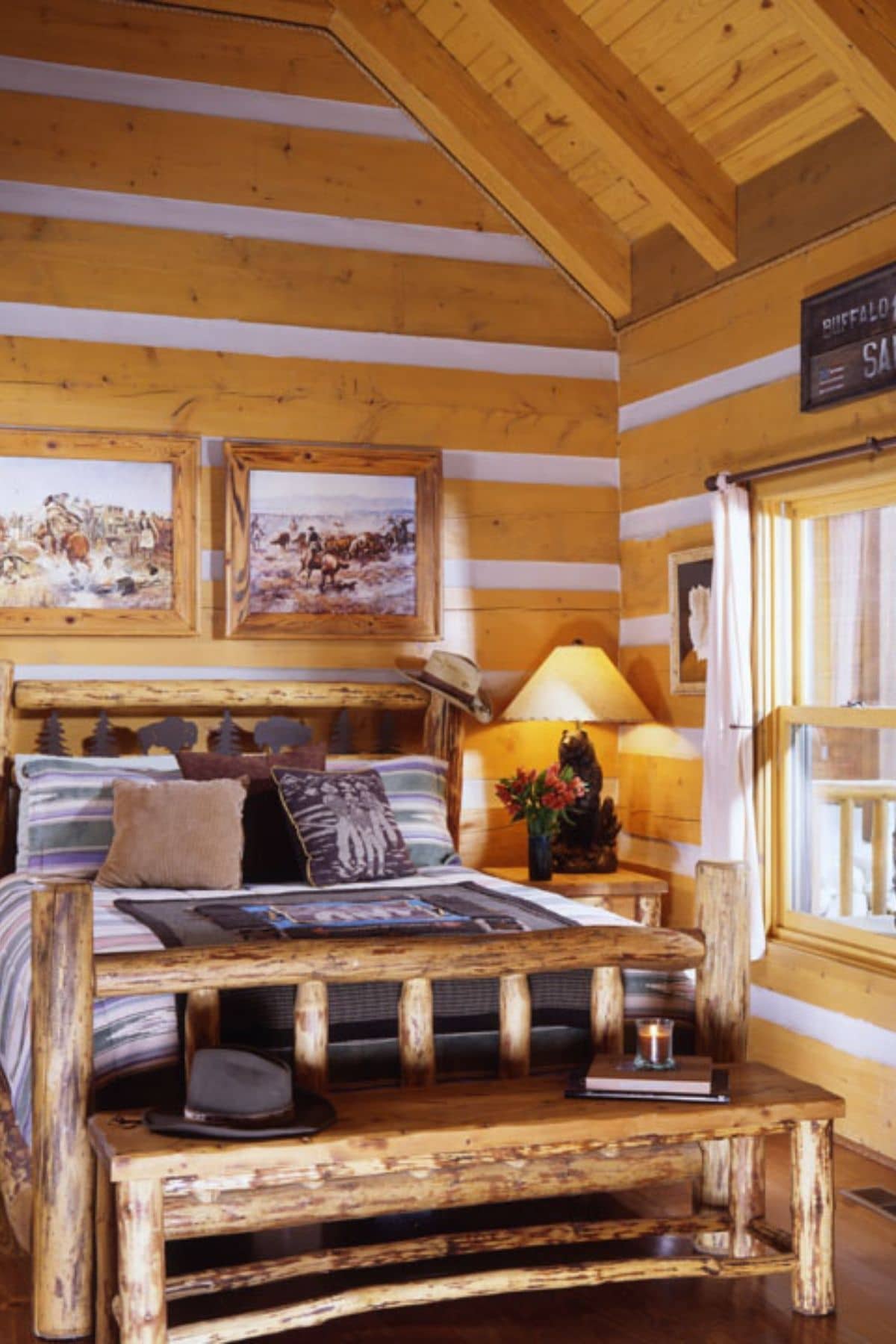 log bed against log cabin wall with large window on right