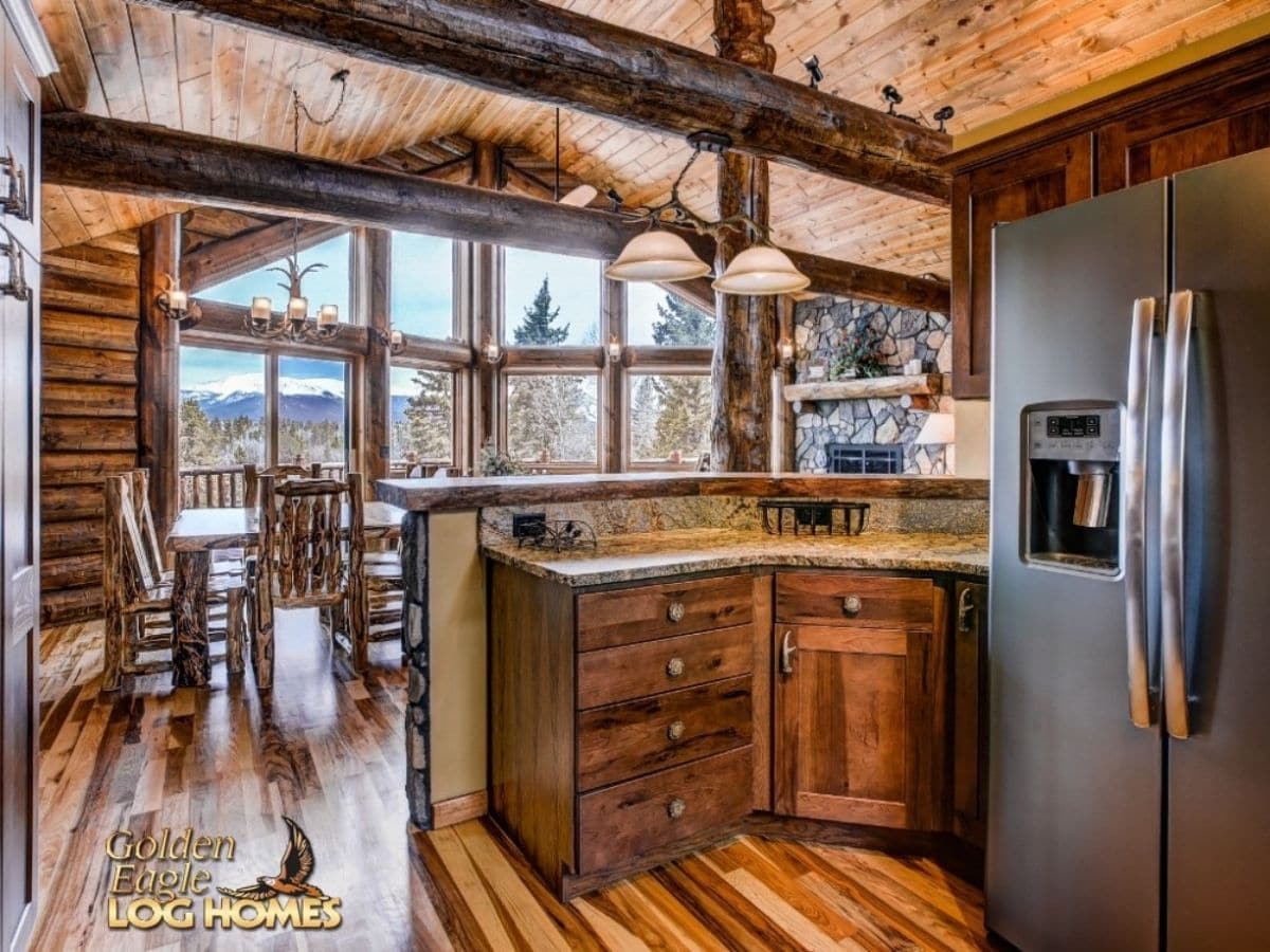 stainless steel refrigerator on right of dark wood cabinets at edge of kitchen