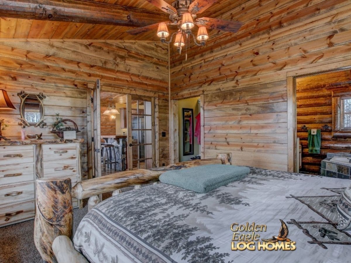 view across bed to doors into bedroom showing kitchen in background