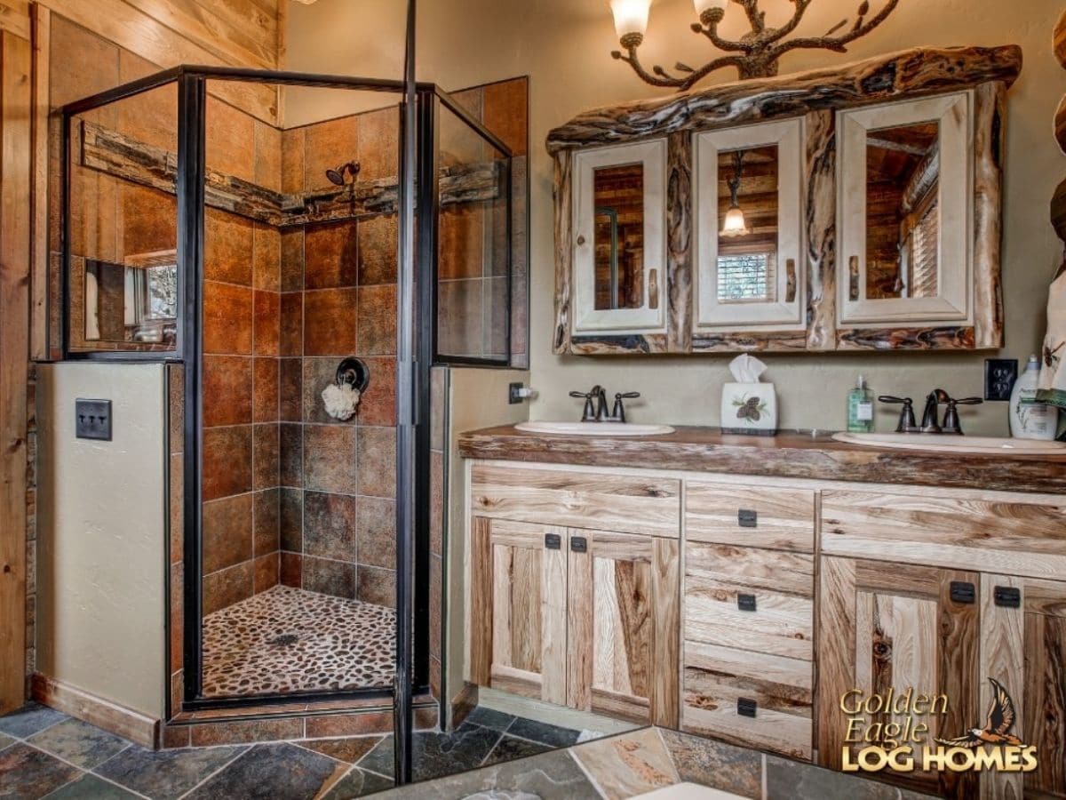 glass shower in corner of bathroom next to light wood cabinets