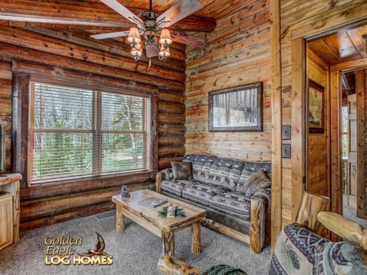 sofa with log base and log cofee table against windows in log cabin