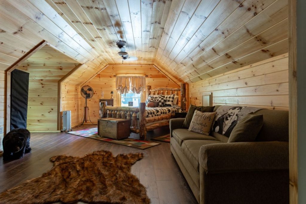 sofa on right wall of loft in log cabin