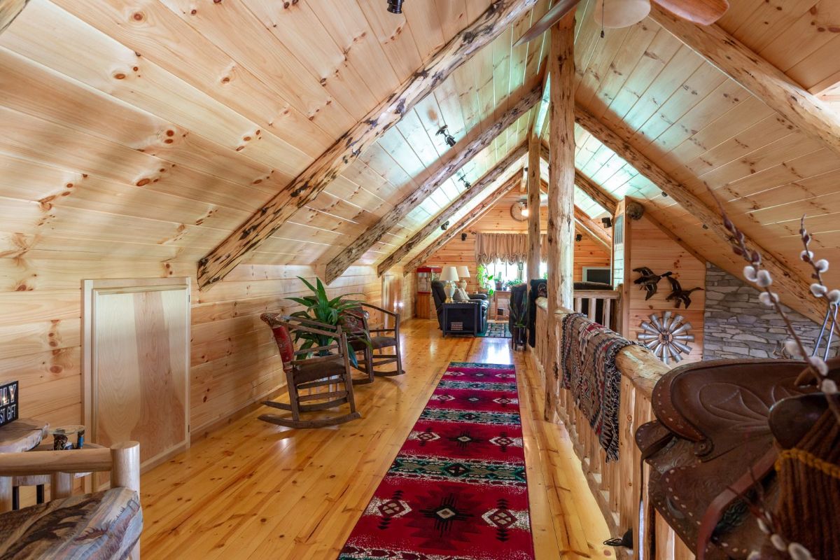 native american rug with red and blue along walkway in log cabin loft