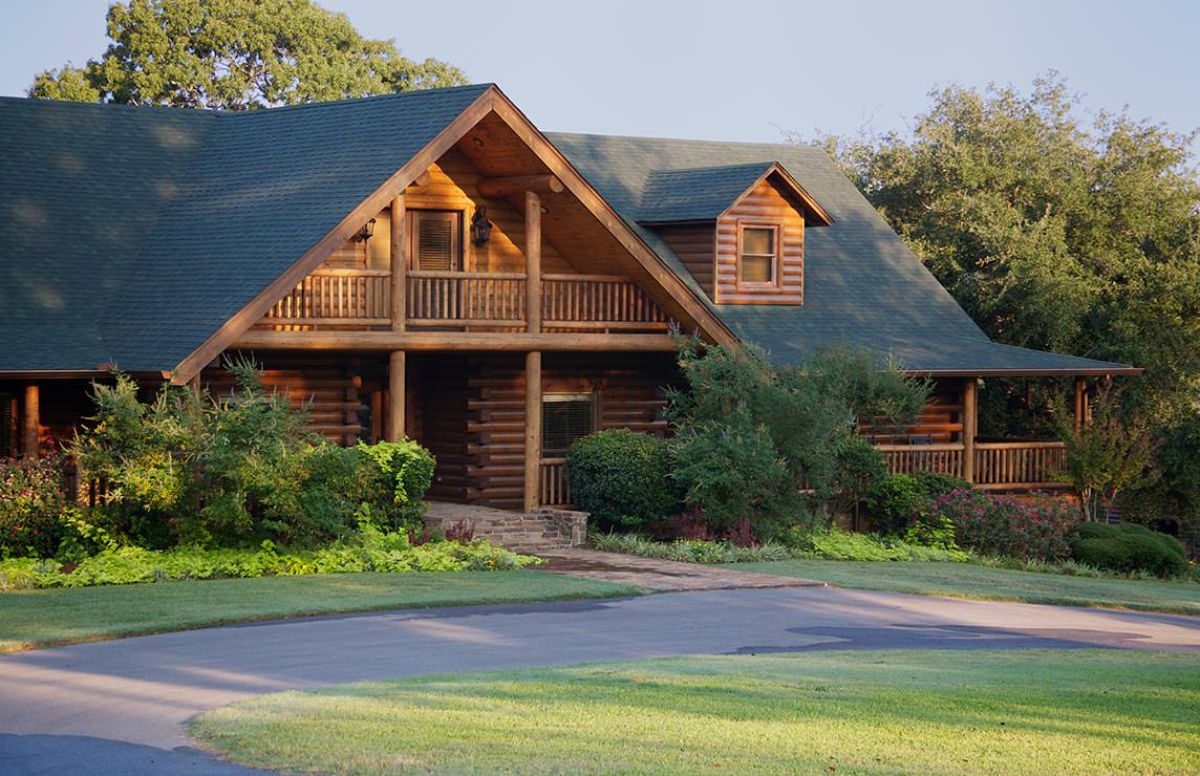 front of log cabin with balcony on second floor