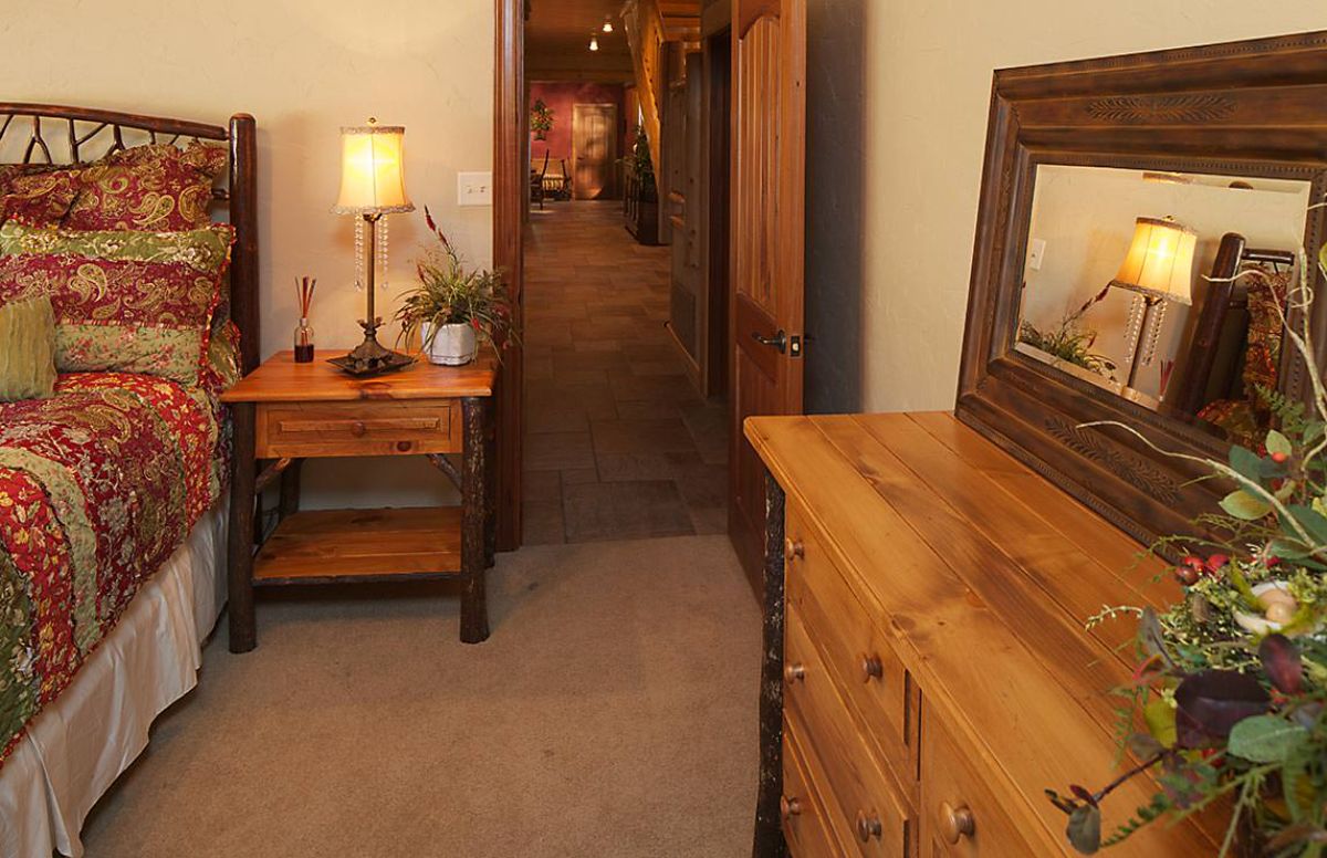 light wood dresser against bedroom wall with wood end table by door