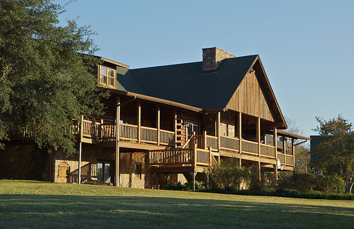 log cabin with two stories and covered porches all around the outside