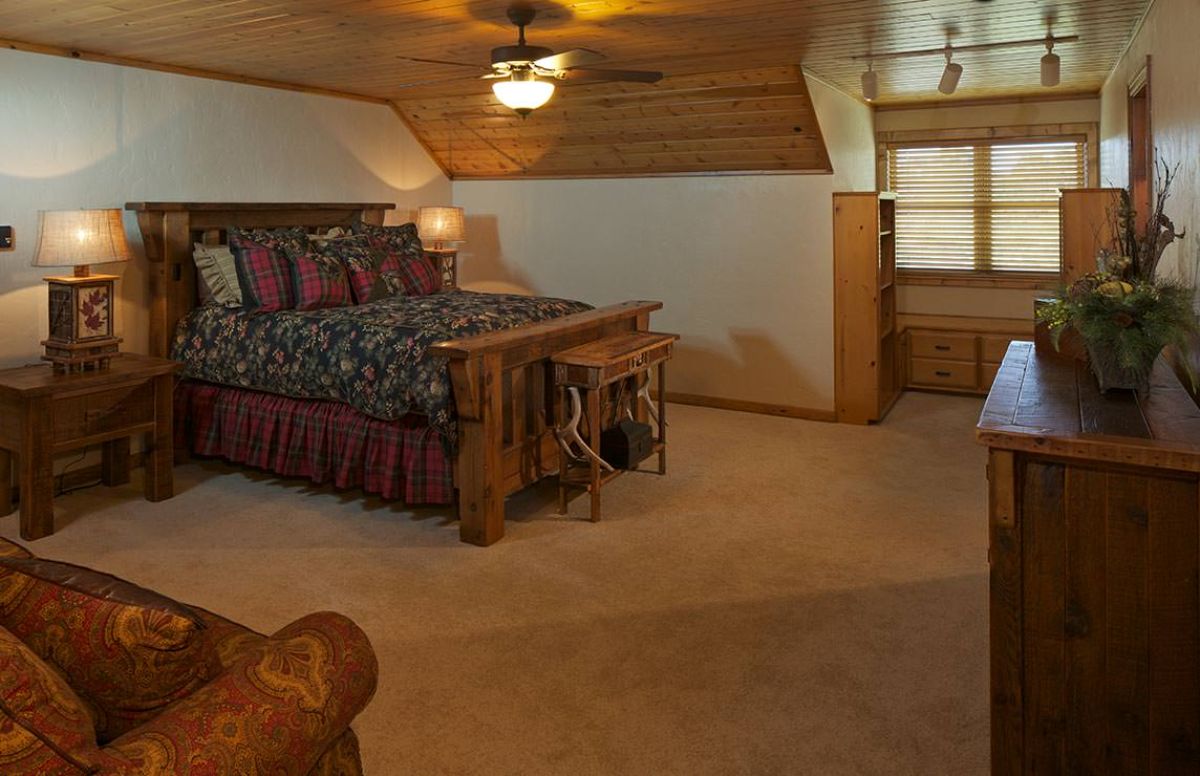 bed against white wall with wood ceiling