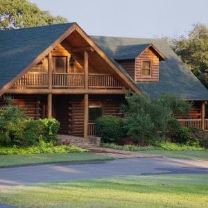 front of log cabin with balcony on second floor