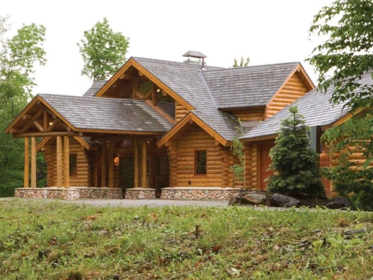 log cabin with extended awning over porch and dark shingles on roof