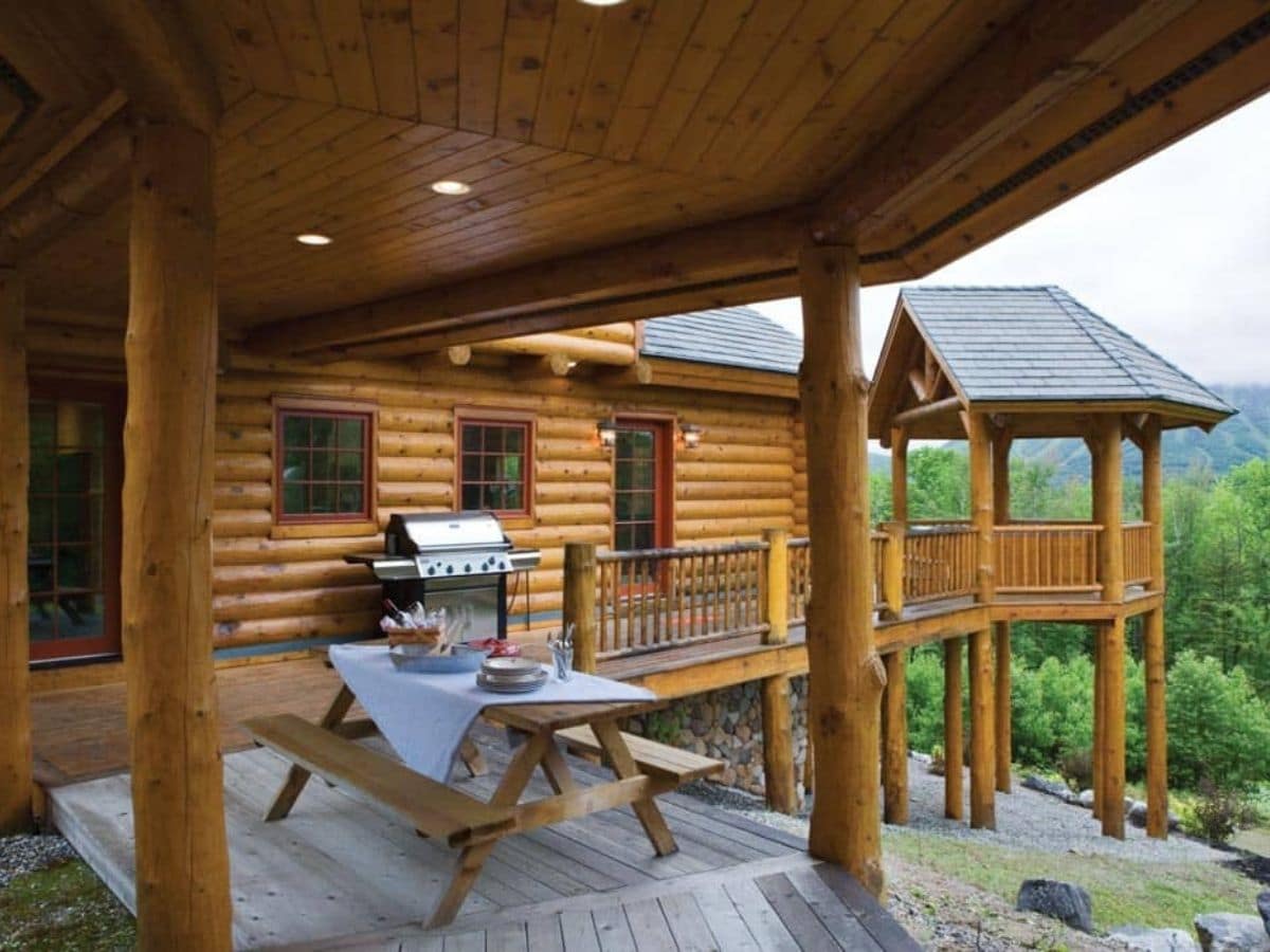 picnic table on deck on back of log cabin