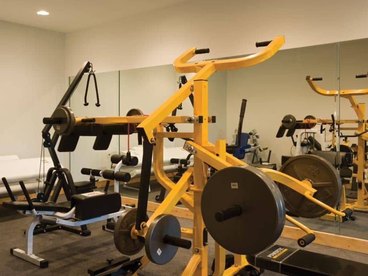gym equipment in front of large mirrored wall