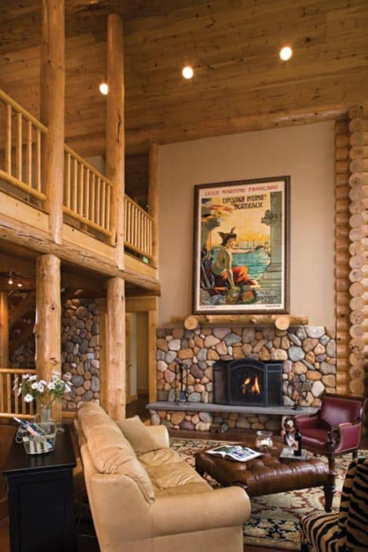 stone fireplace against wall with large cowboy image above next to log columns below loft