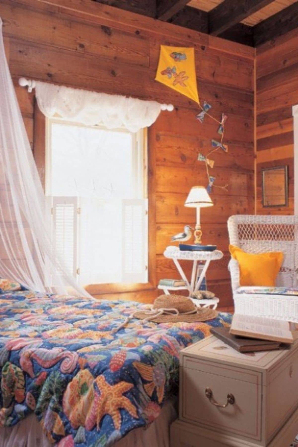 bedroom with large white window and white chair in log cabin