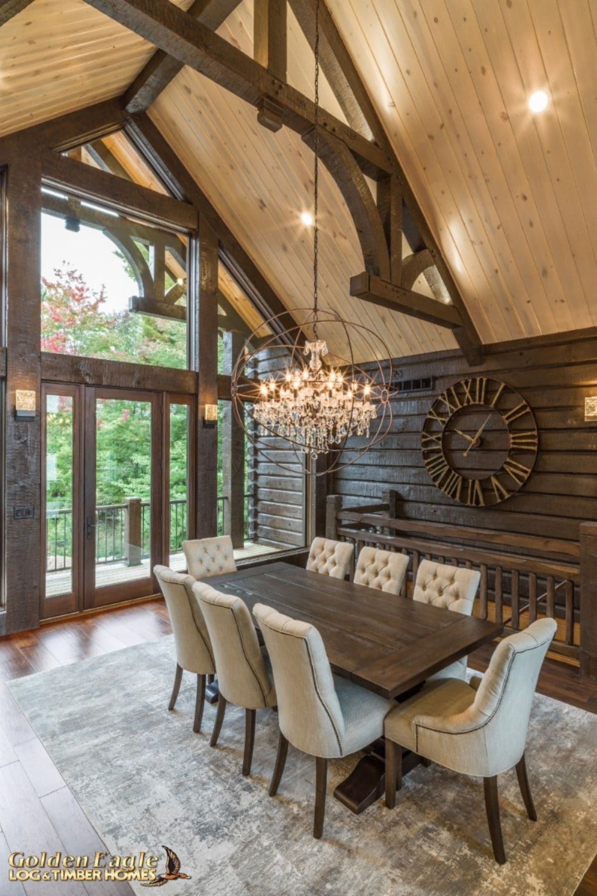 dark wood table with gray chairs below chandelier