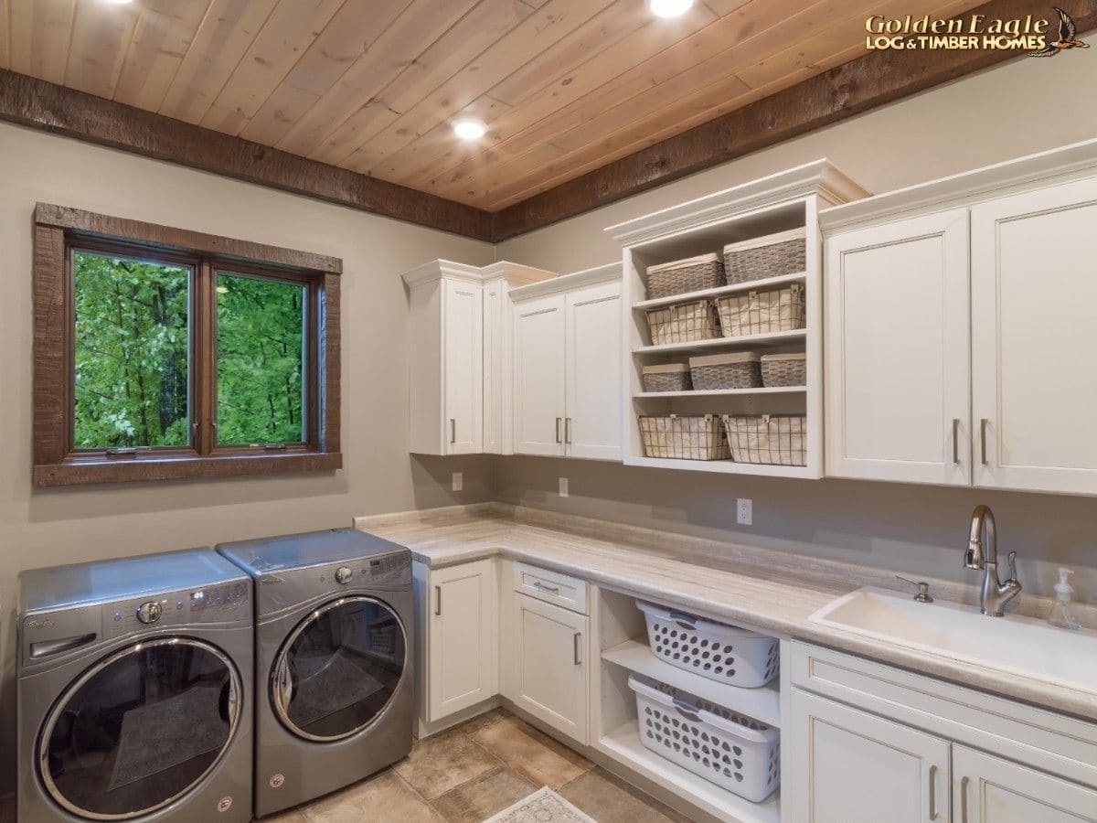 white cabinets and shelves in laundry room with stainless steel washer and dryer