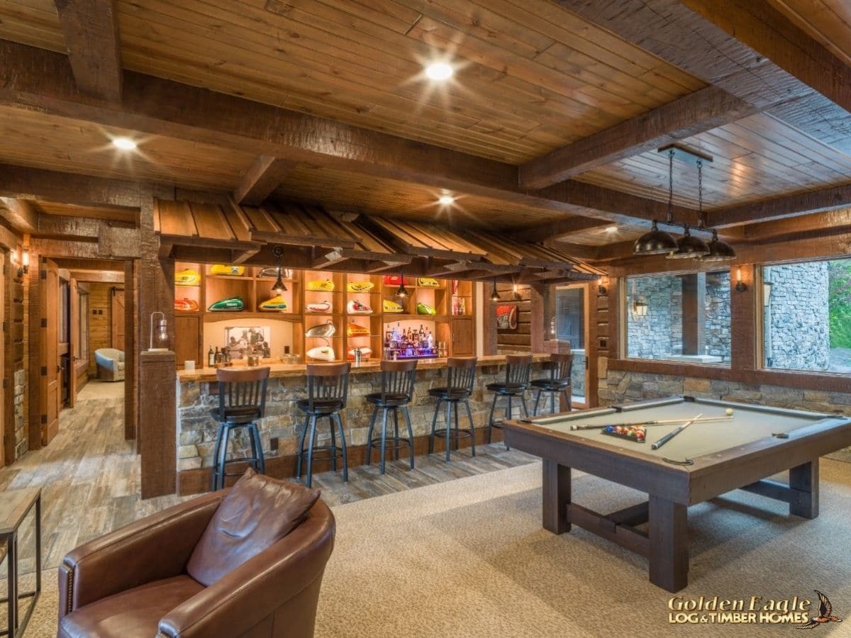 long bar behind pool table in log cabin basement