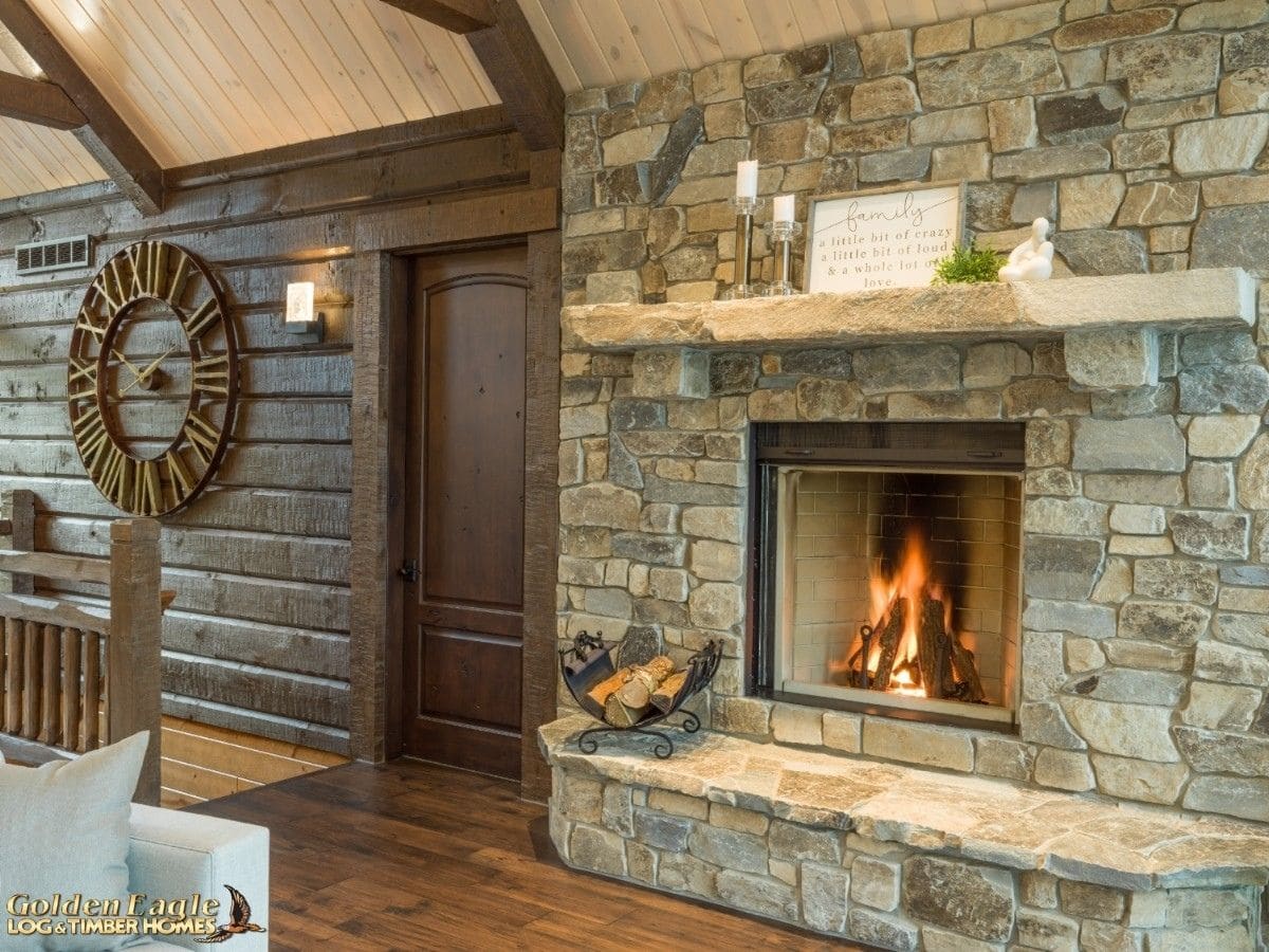 stone fireplace next to dark wood walls with door to left