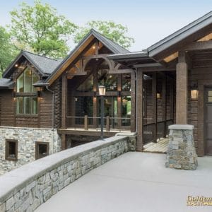 driveway and walkway of log cabin with stone rail