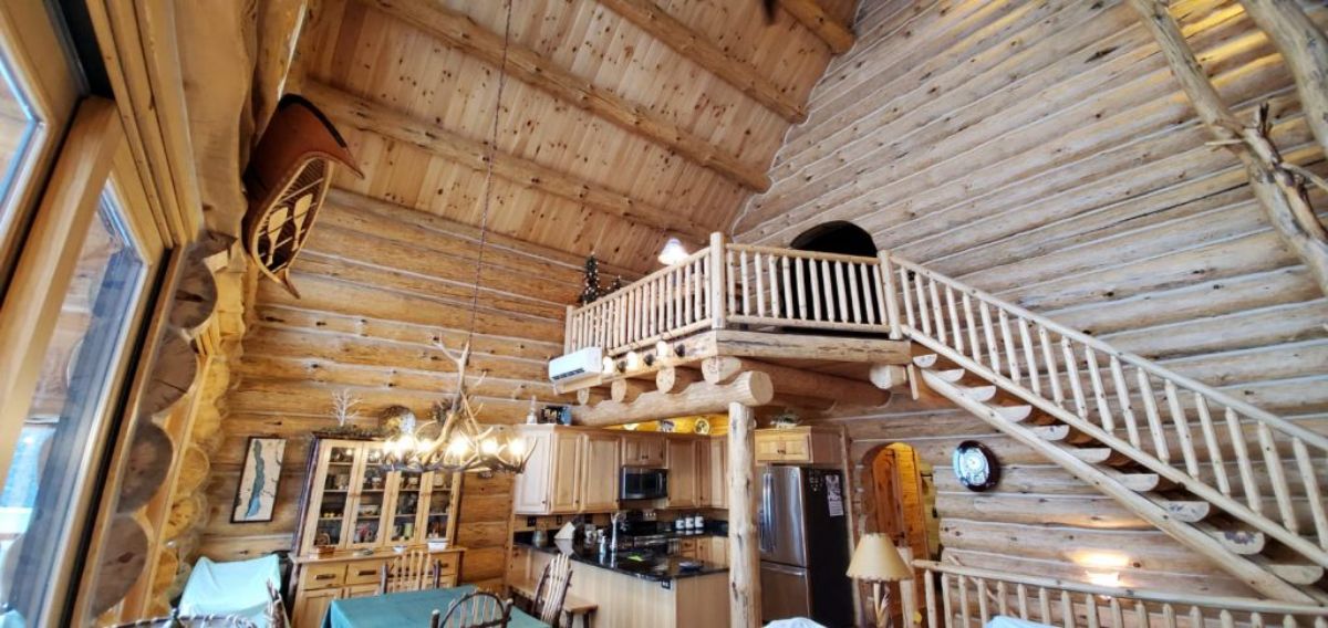 light wood log loft overlooking living room space