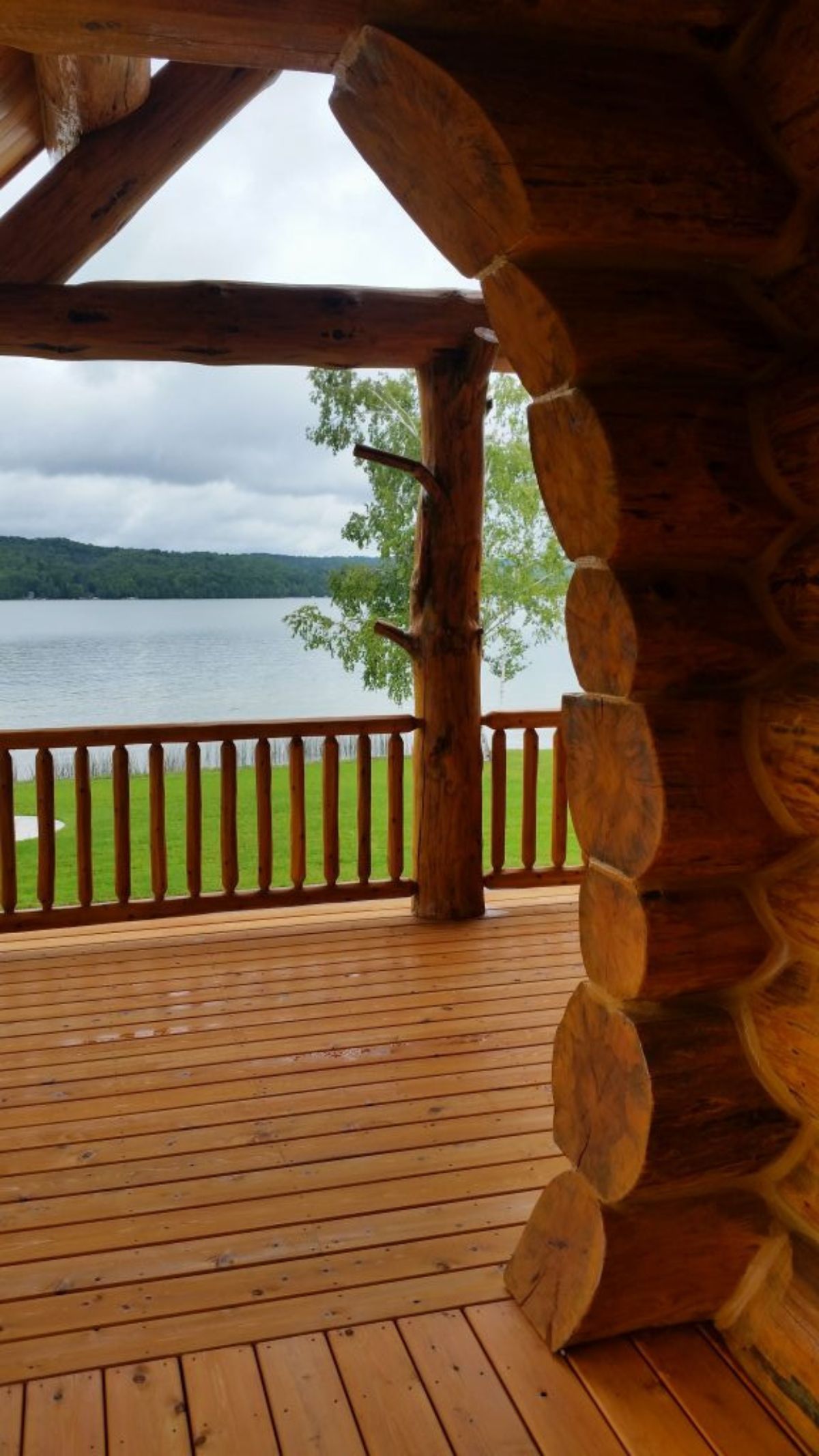 view through log archway off deck with wood railing