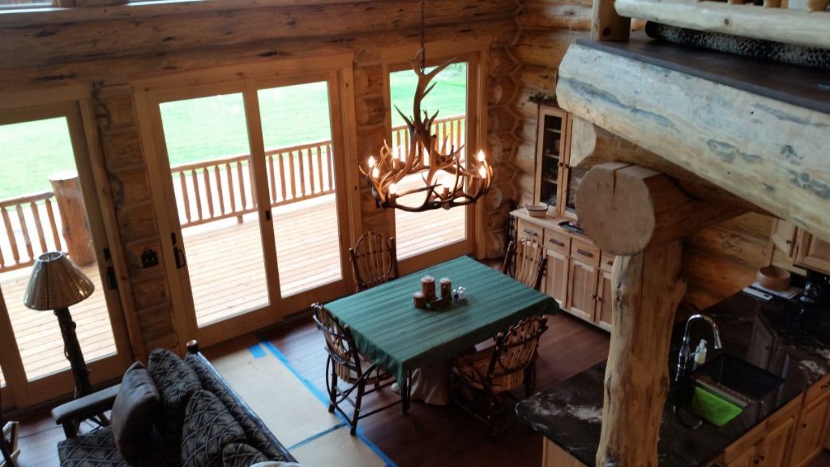 view from loft into dining room with antler chandelier above table