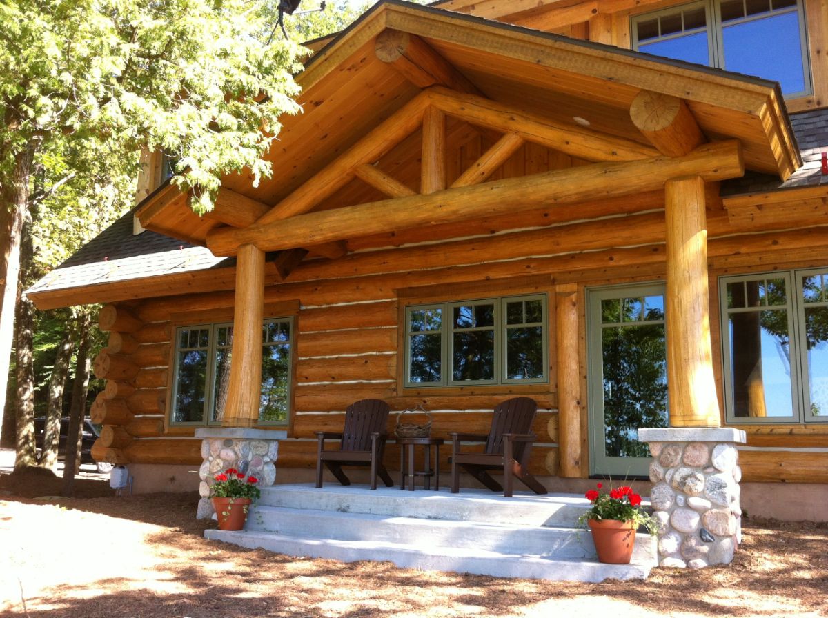 front of log cabin with awning over small concrete porch