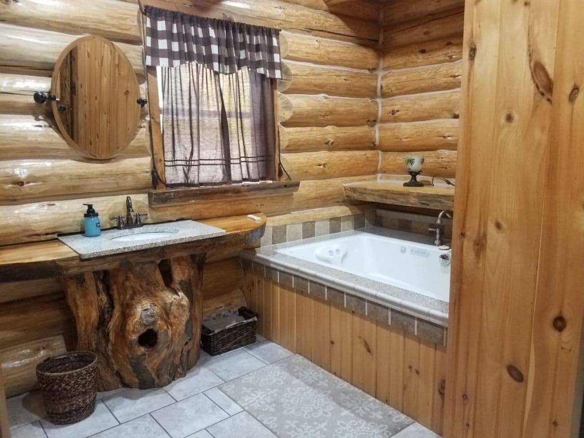 soaking tub behind tile and wood in log cabin bathroom