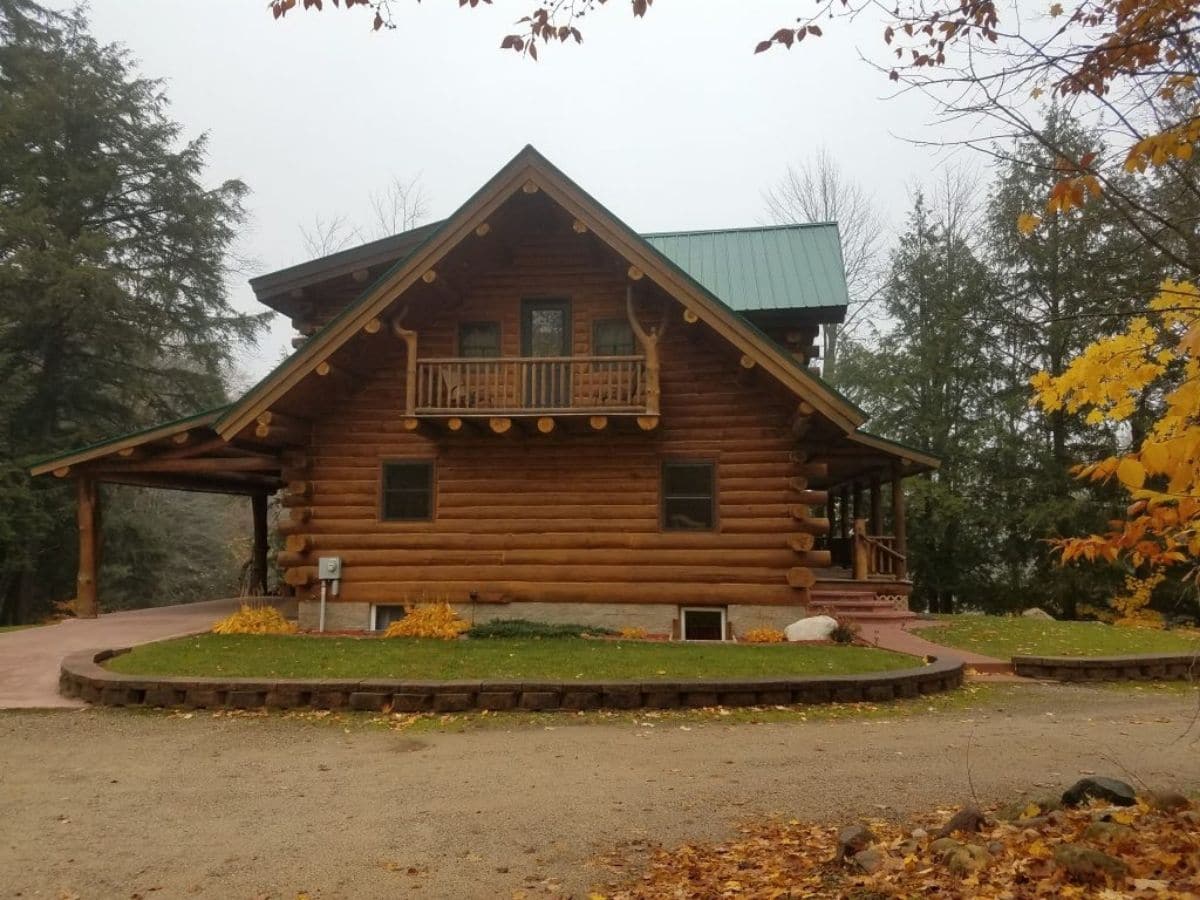 side of log cabin with circle driveaway