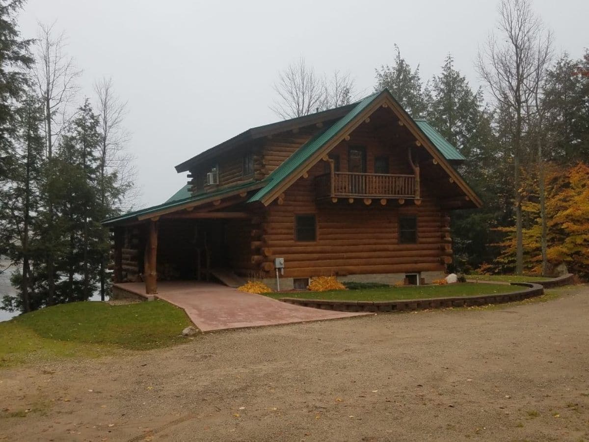 side of log cabin showing carport and driveaway