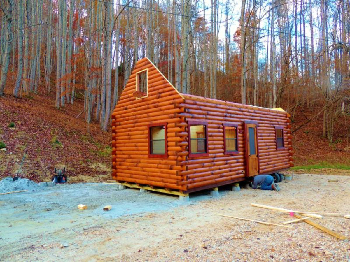 log cabin against treeline with no roof on top