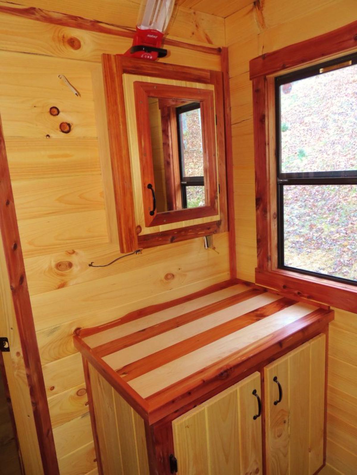 cabinet with mirror above and two tone butcher block counter