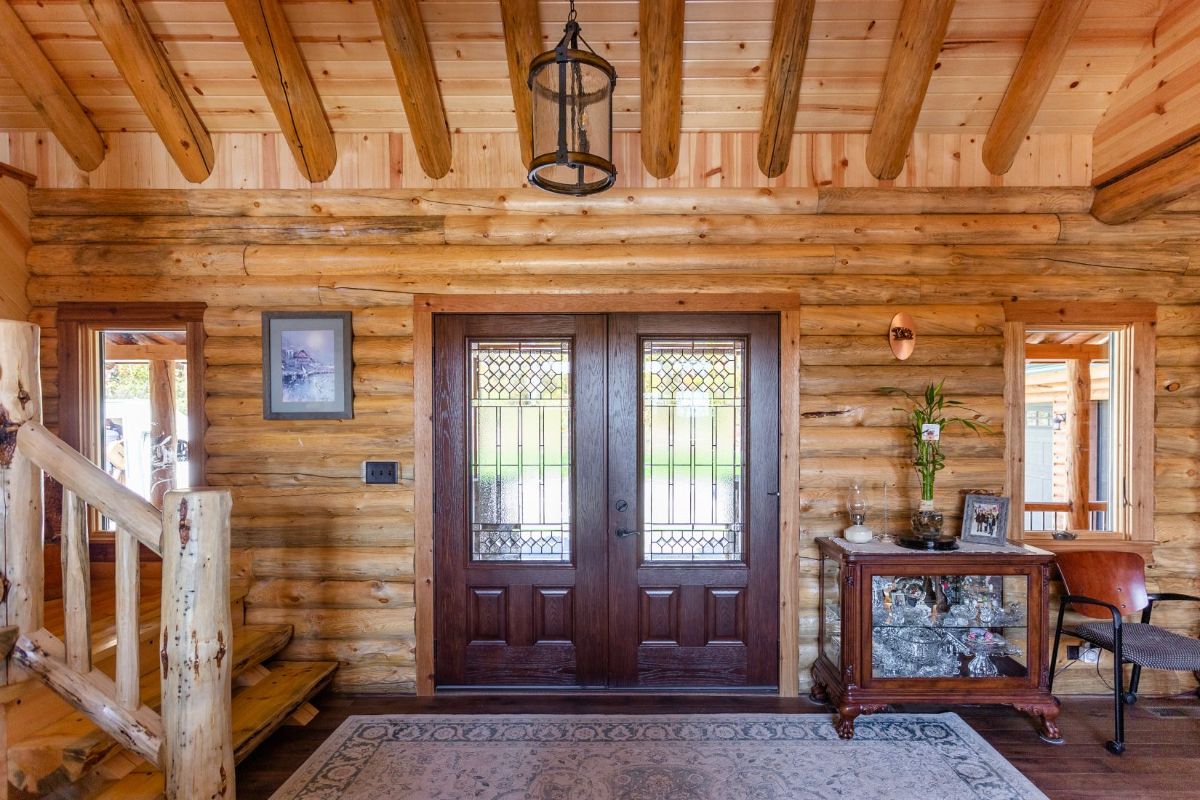 dark wood doors at log cabin entry with glass panes
