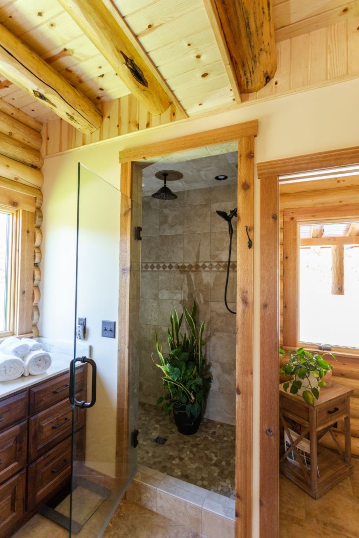 glass door shower inside bathroom with dark wood vanity and white top