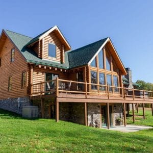 log cabin with back side porch and stone basement along with green roof