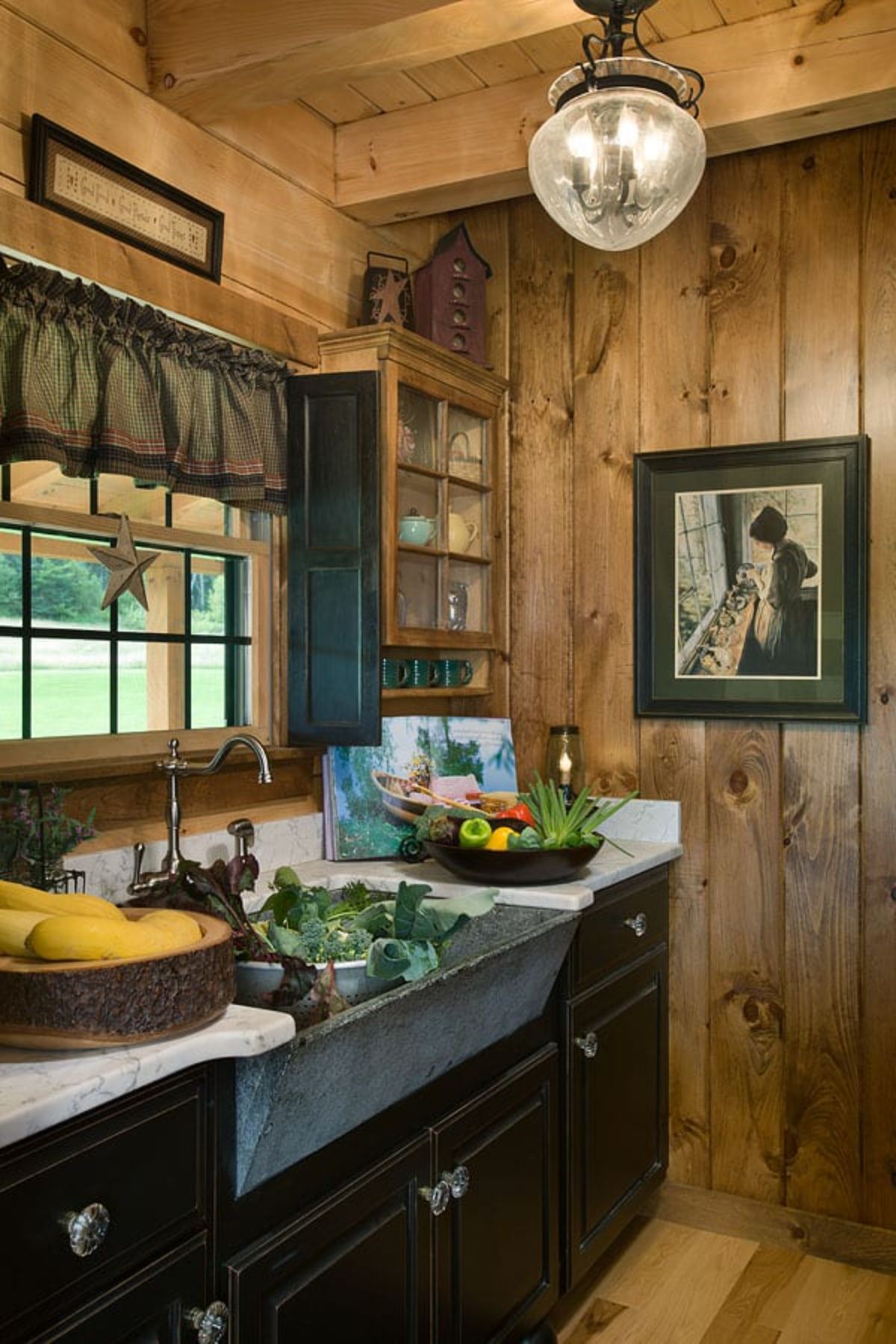 sink in dark wood cabinets filled with greens