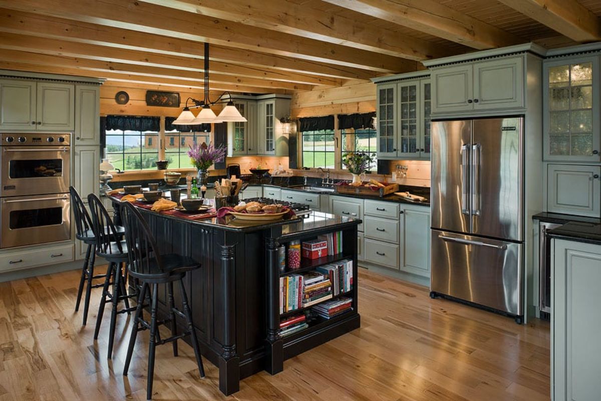 black island in kitchen with light green cabinets and stainless steel appliances