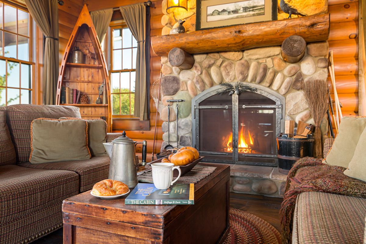 wood coffee table in front of stone fireplace