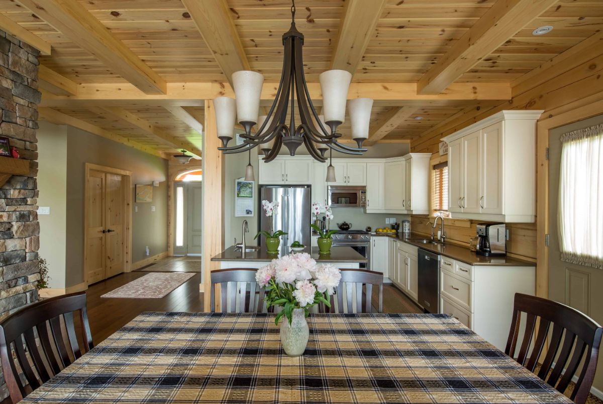 view over table to kitchen with light wood cabinets