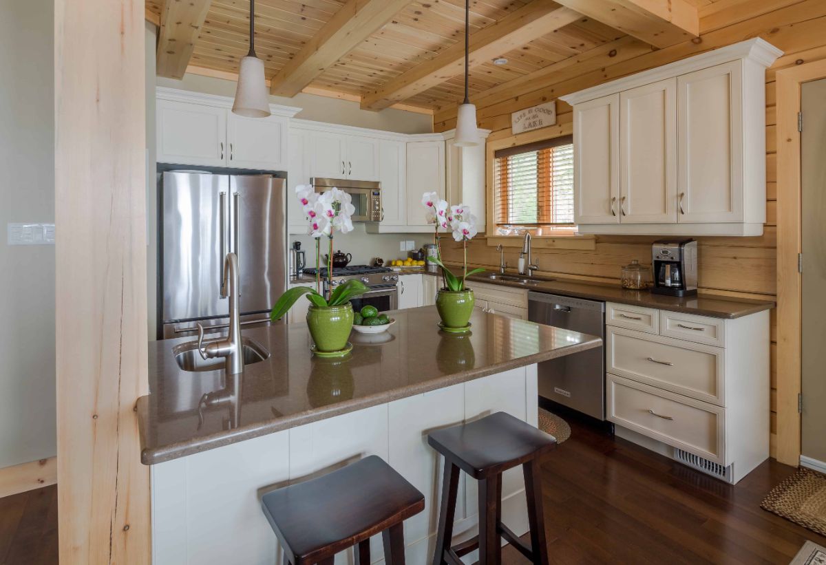 island with two wood barstools against light wood cabinets